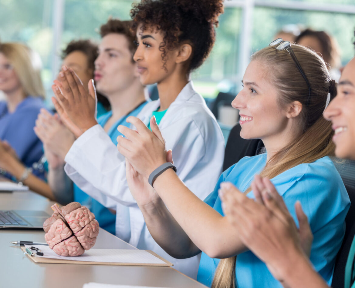Diverse group of pre-med students applaud in class