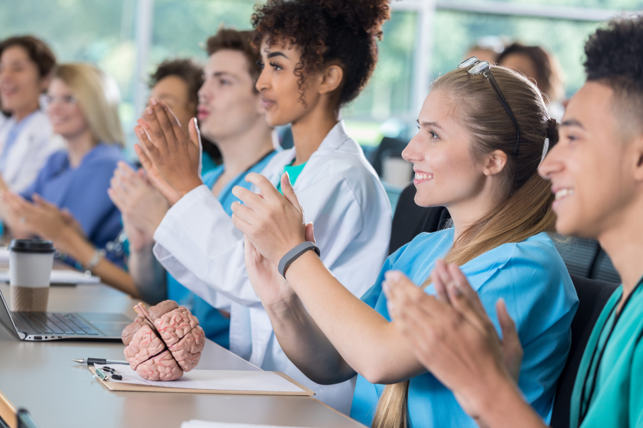 Diverse group of pre-med students applaud in class