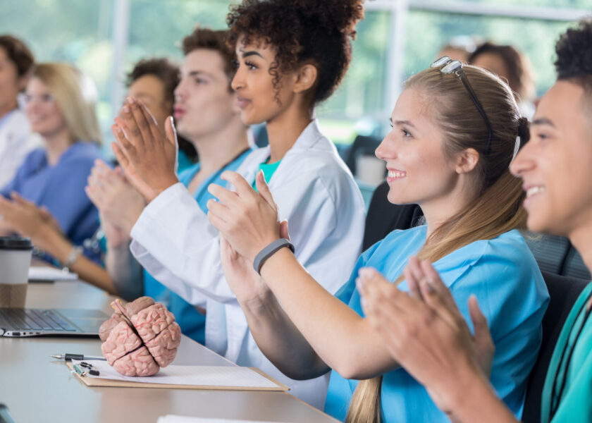 Diverse group of pre-med students applaud in class